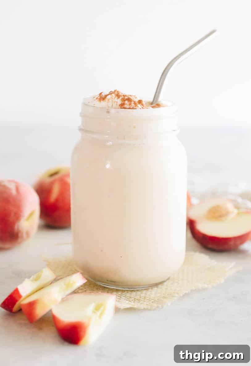 A vibrant, perfectly blended peach smoothie served in a clear mason jar, garnished for refreshing summer appeal.
