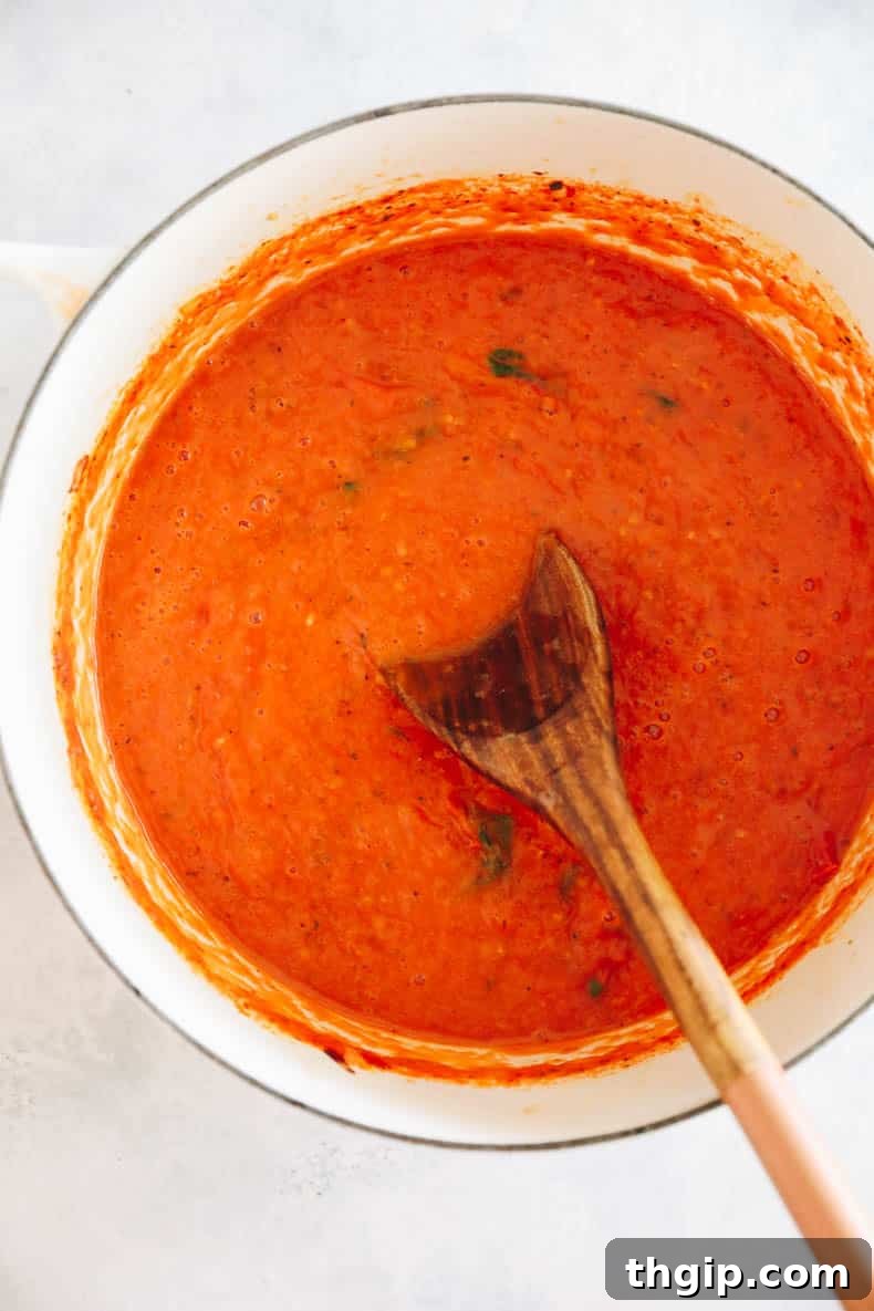 Slow Simmered Tomato Sauce 6 Smooth, blended homemade tomato sauce glistening in a large Dutch oven, ready to be enjoyed.