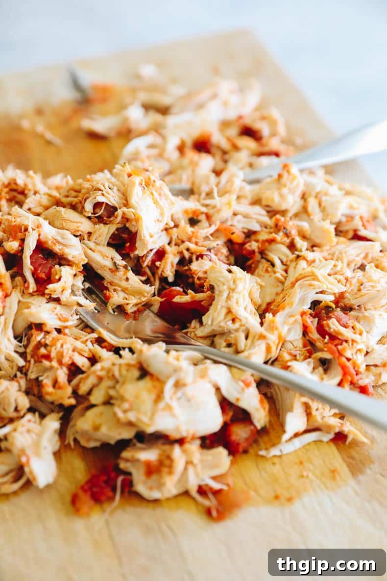 Spicy Instant Pot Chicken Fiesta 4 Perfectly shredded Salsa Chicken on a cutting board, ready for its next step.