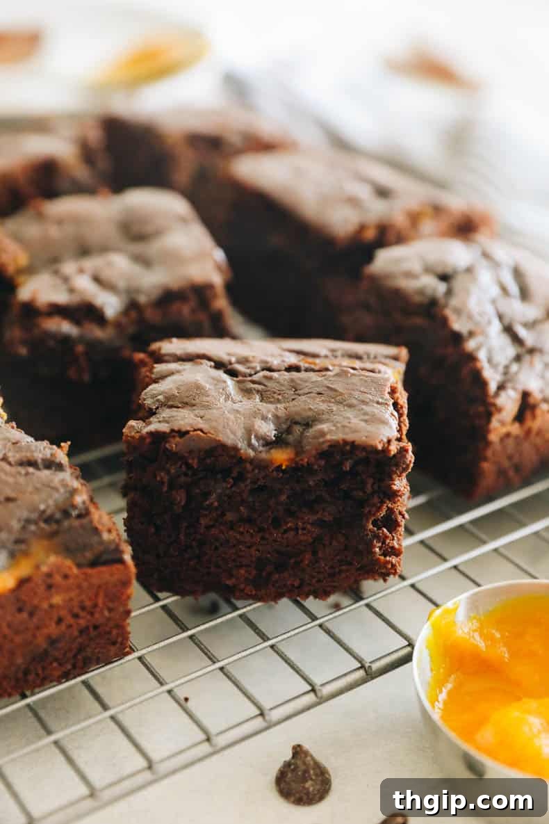 Autumn Pumpkin Brownies 7 Close-up image of a perfectly baked pumpkin brownie on a wire rack, showing its fudgy interior.