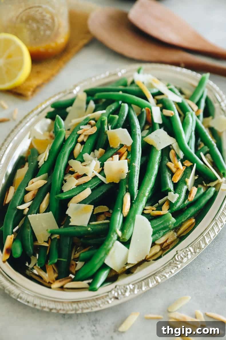 Vibrant Bean Delight 2 green bean salad topped with parmesan and toasted almonds on a silver platter.