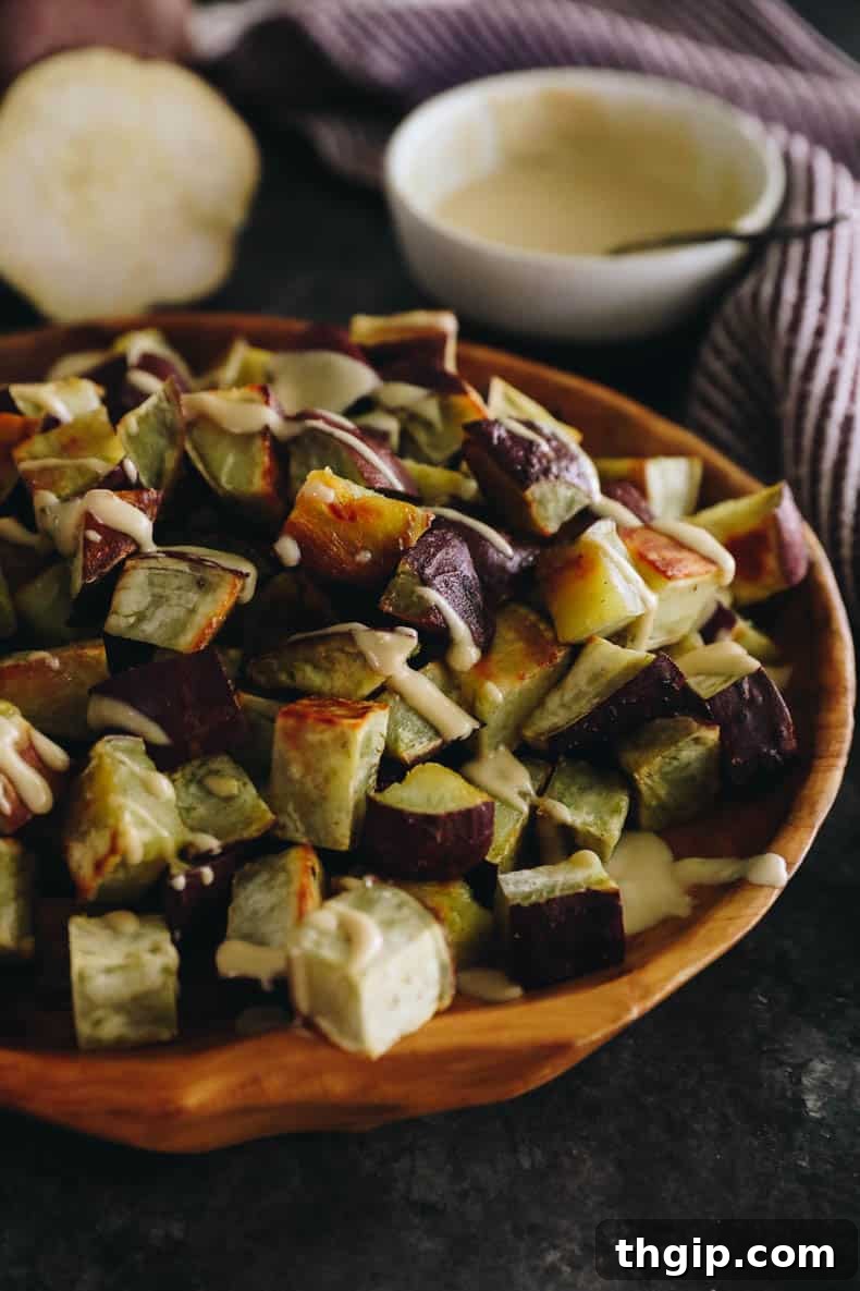 Sweet & Creamy Roasted Japanese Sweet Potato 2 Cubed and roasted Japanese sweet potato topped with a miso sesame dressing in a brown shallow bowl, garnished with sesame seeds.