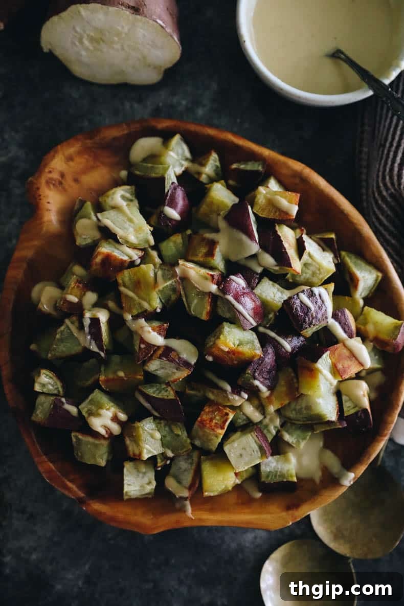 Sweet & Creamy Roasted Japanese Sweet Potato 8 A close-up shot of roasted Japanese sweet potato cubes in a rustic bowl, with a hint of tahini miso dressing and fresh herbs.