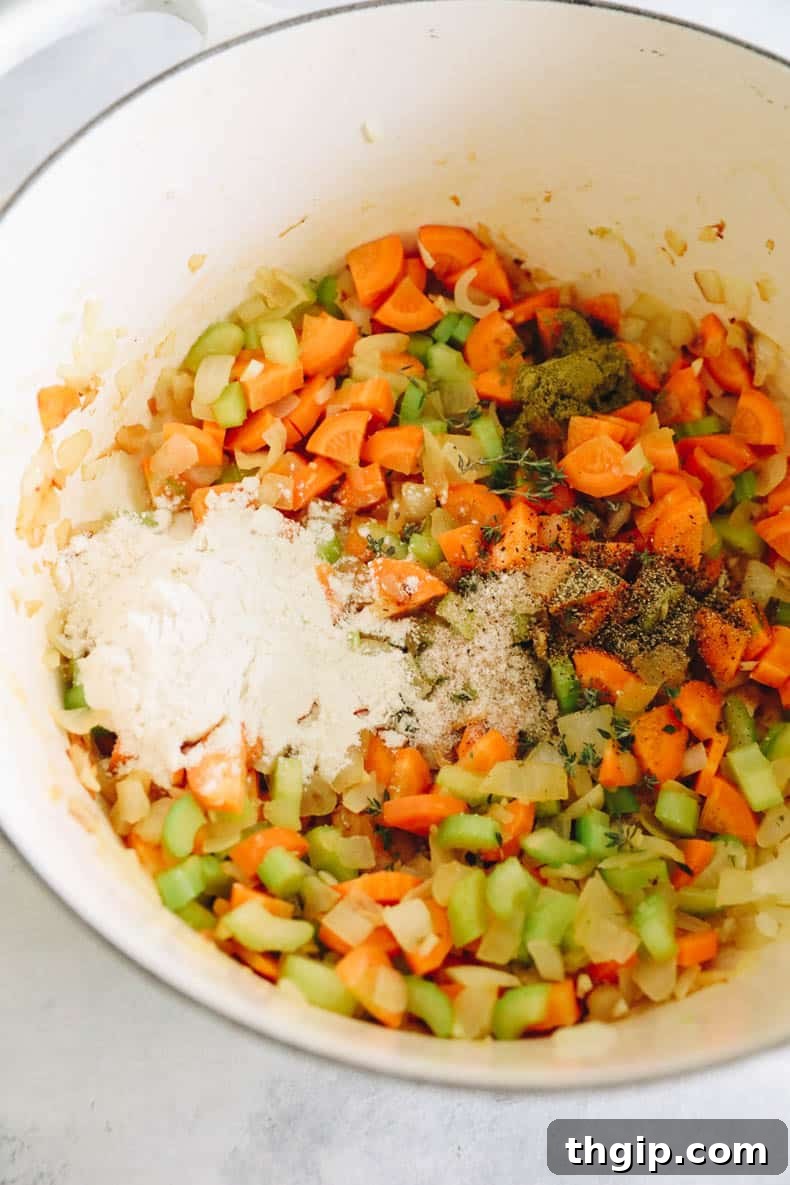 Creamy Chicken Wild Rice Delight 4 A cook adding fresh thyme, dried sage, salt, pepper, and all-purpose flour to the sautéed vegetables in a white Dutch oven, creating a flavorful roux for the soup.