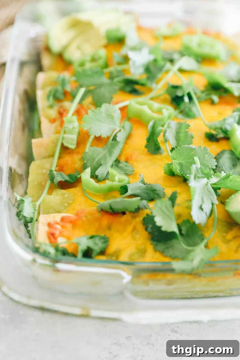 Zesty Green Enchilada Sauce 7 green chicken enchiladas topped with cheese and baked in a pyrex dish.