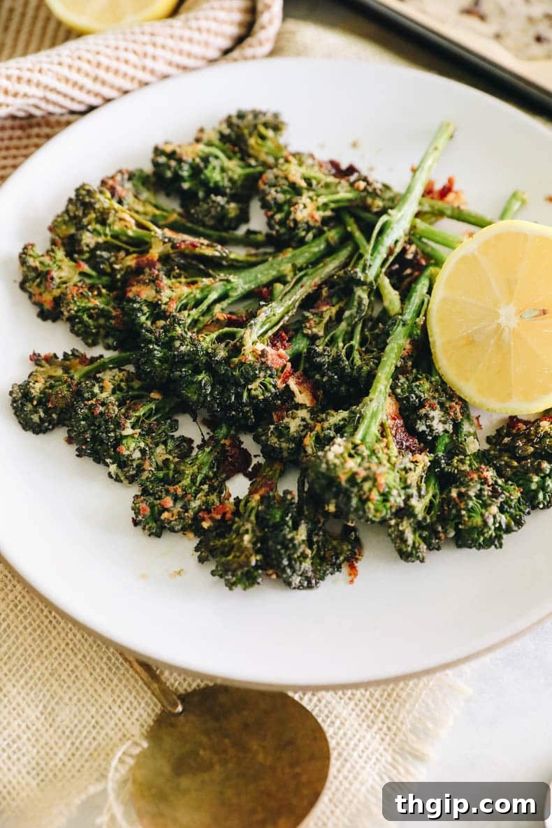 Golden Roasted Broccolini 6 roasted broccolini on a white plate with lemon.