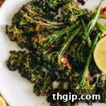 roasted broccolini with lemon on a white plate with parmesan.