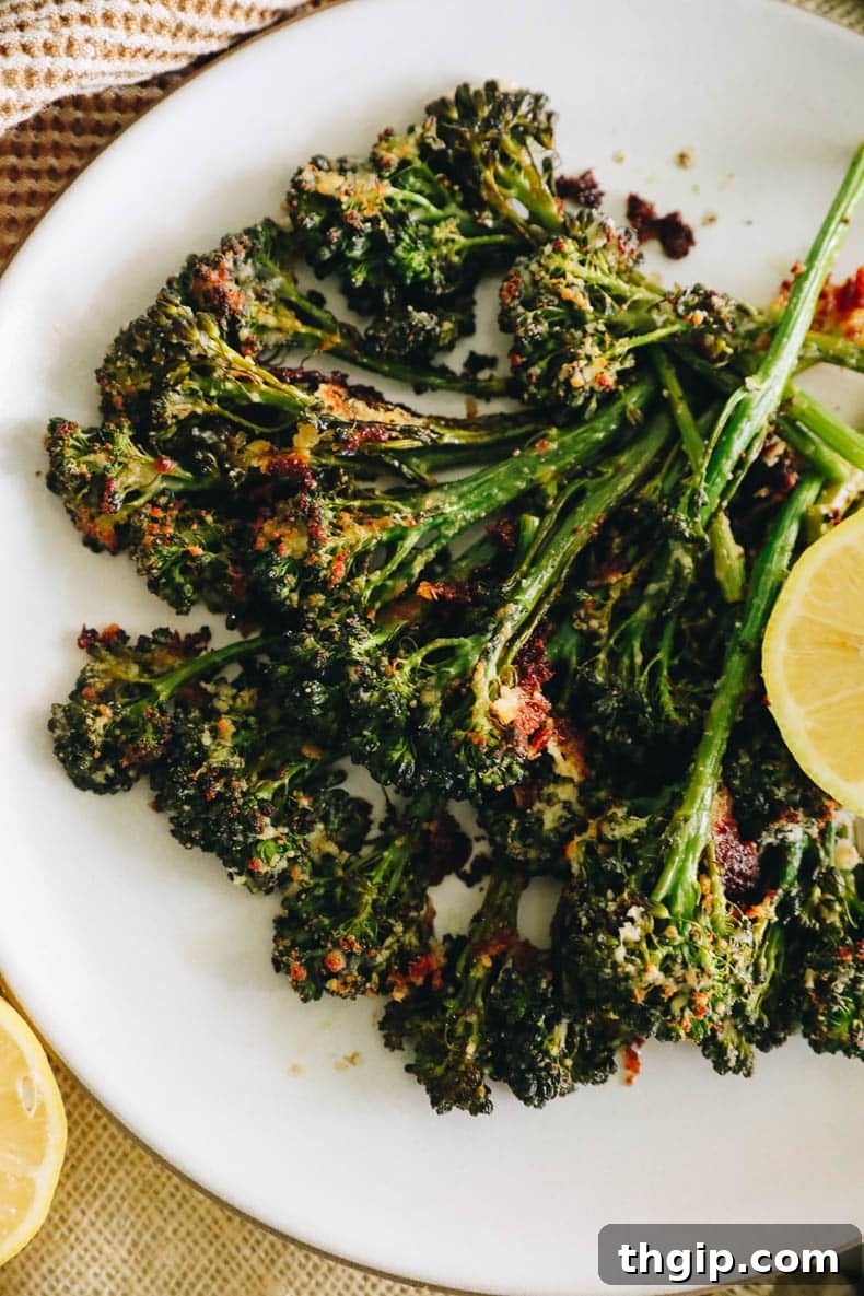 Golden Roasted Broccolini 8 Overhead image of roasted broccolini on a white plate with charred parmesan and lemon.
