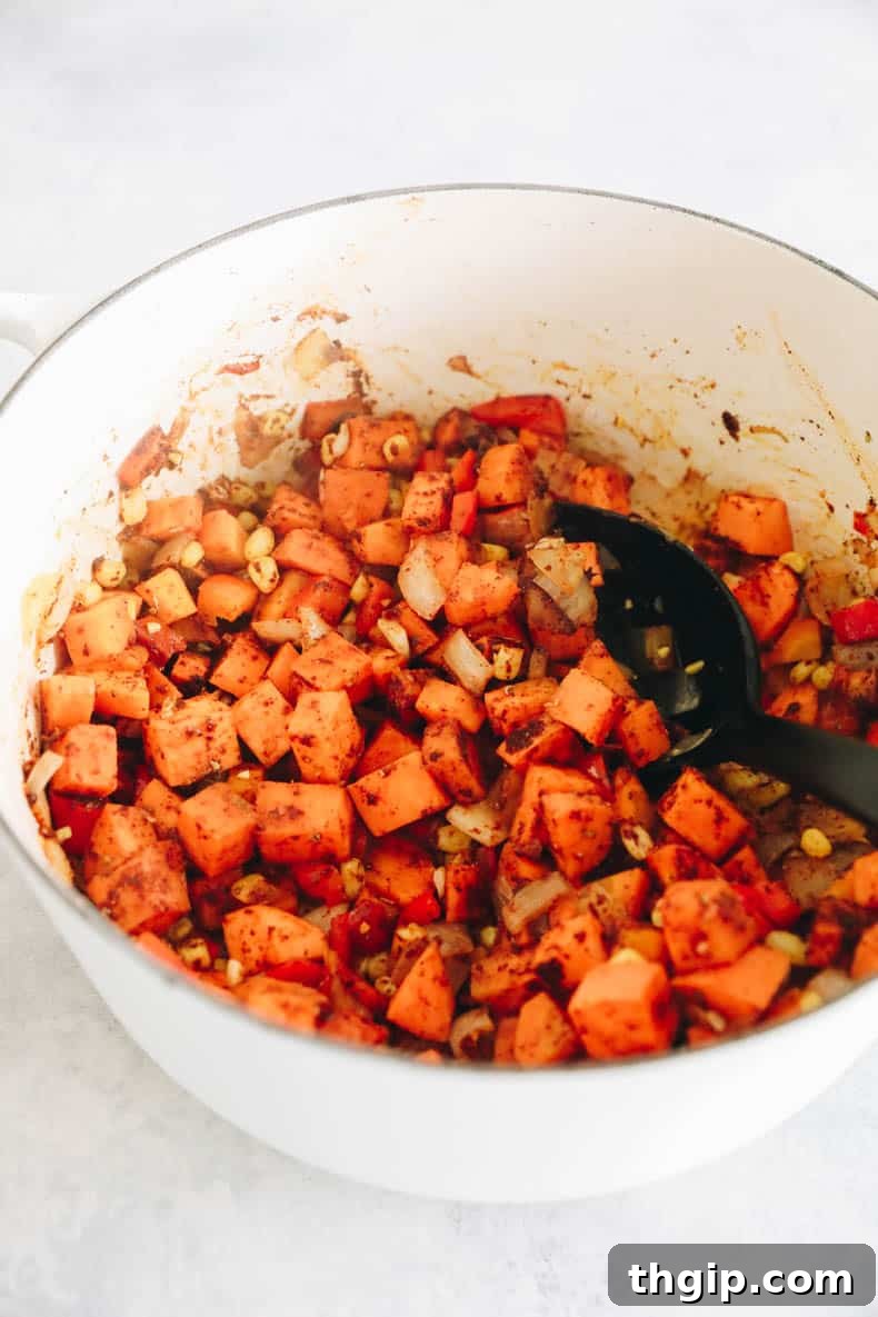 Wholesome Plant-Based Chili 3 A large Dutch oven on the stove filled with freshly sautéed vegetables and aromatic spices, a vibrant start to a healthy chili recipe.
