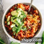 The ultimate healthy veggie chili recipe, beautifully presented in a white bowl with a variety of fresh, colorful toppings, ready to be served.
