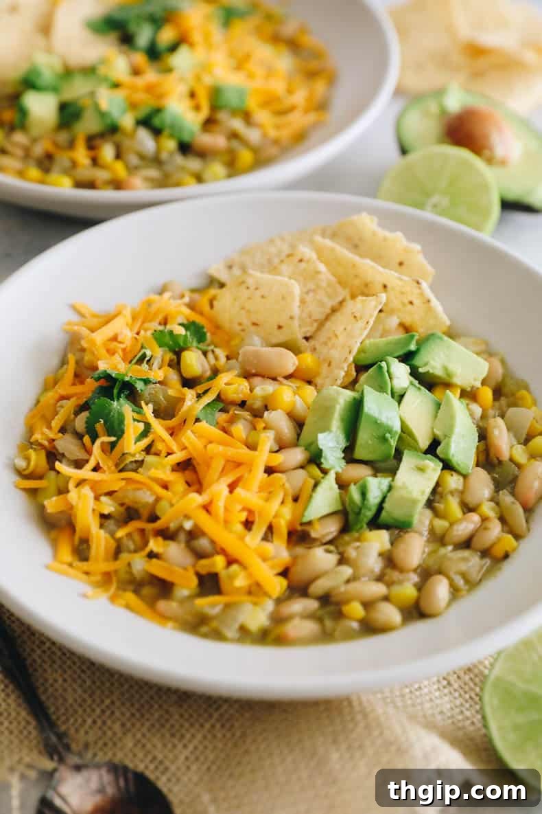 Creamy White Bean Chili 2 A vibrant bowl of white bean chili, garnished with fresh cilantro and a dollop of sour cream or Greek yogurt, ready to be enjoyed.