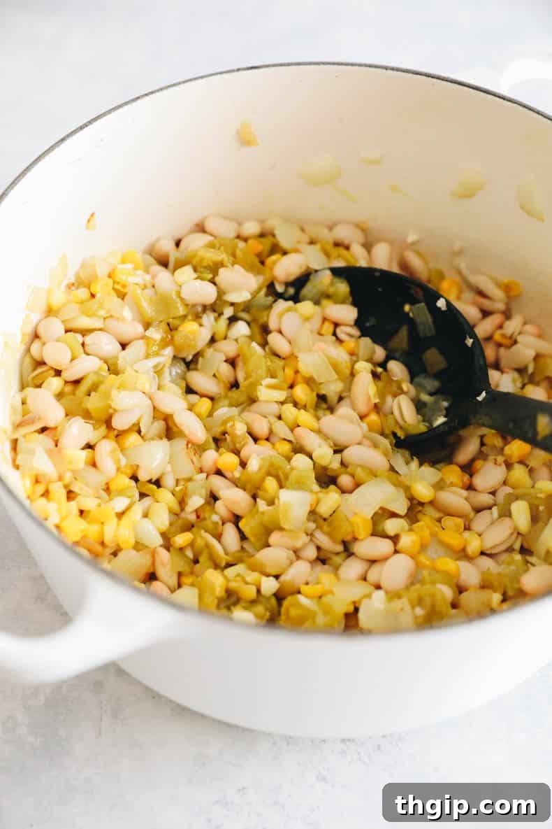 Creamy White Bean Chili 4 Sautéed onions, garlic, whole white beans, corn, and green chiles simmering in a white Dutch oven.