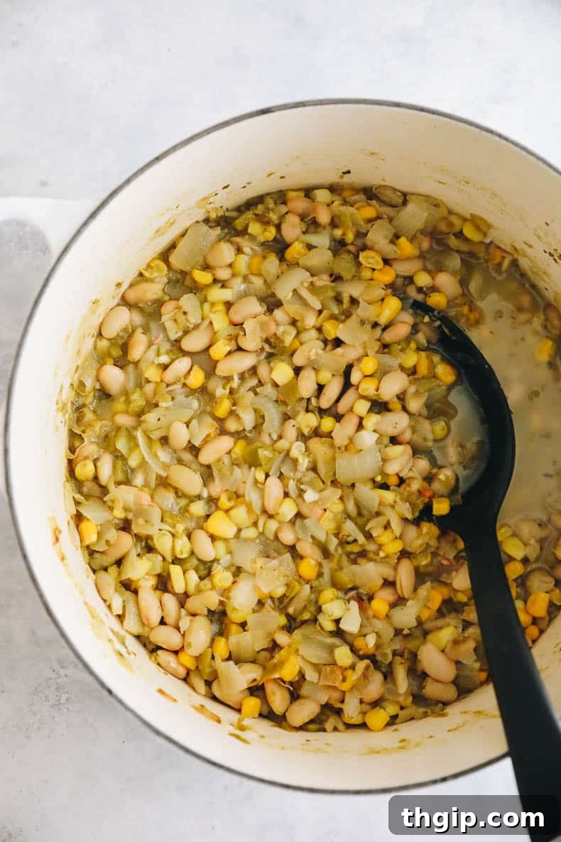 Creamy White Bean Chili 5 White bean chili simmering gently in a white Dutch oven, its flavors developing.
