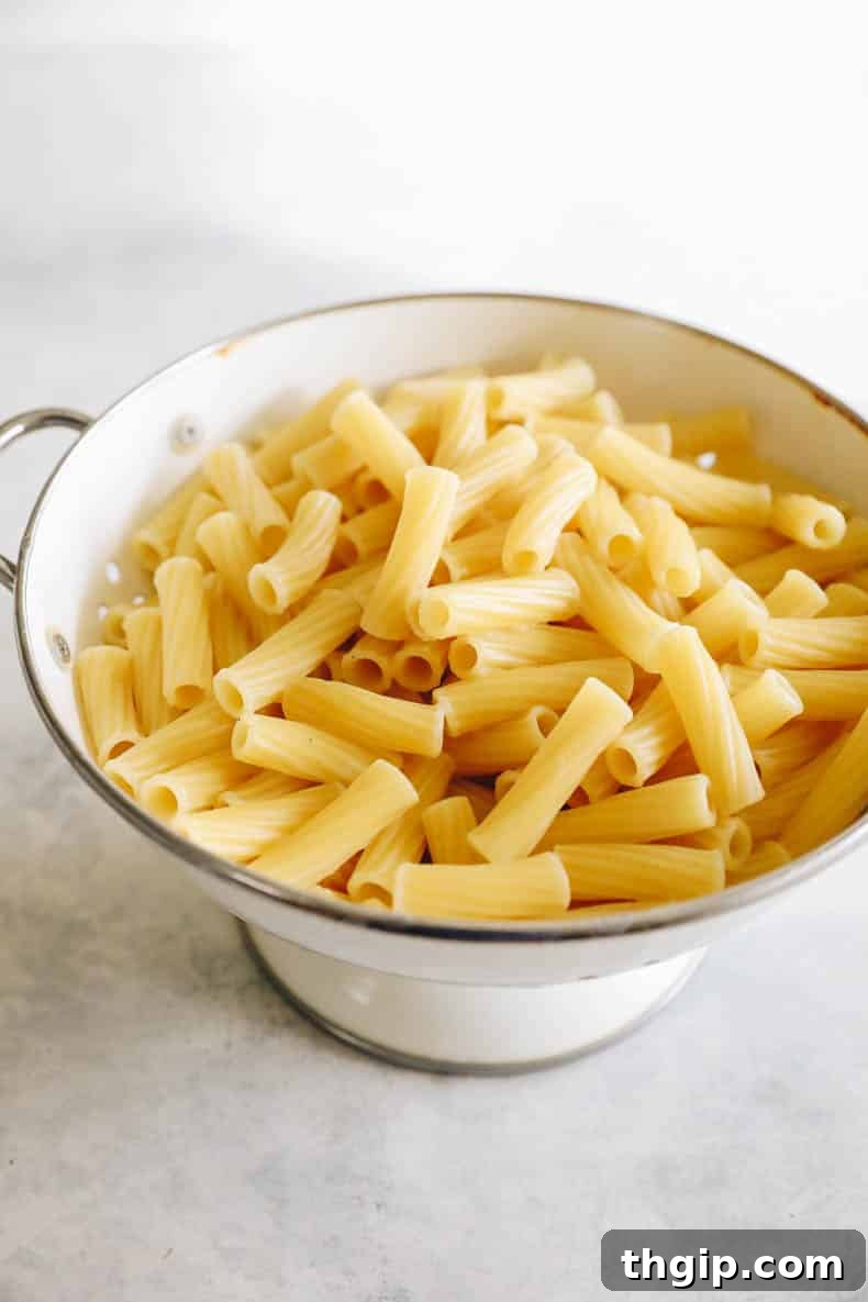 cooked and strained rigatoni in a white colander.