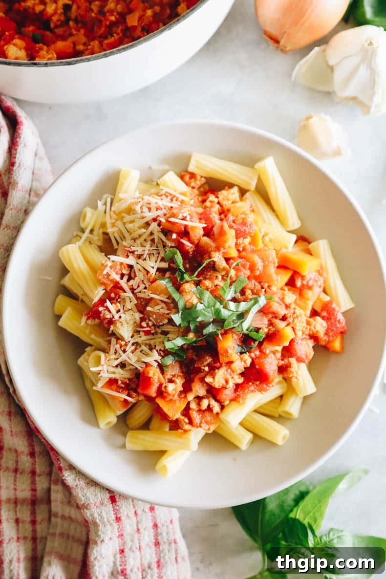 Rigatoni bolognese with chopped basil and parmesan cheese.