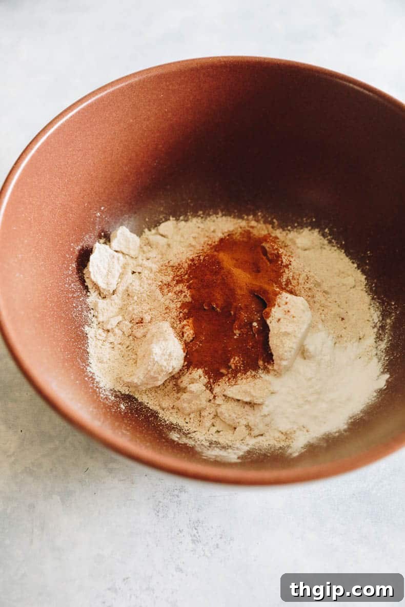 Golden Oat Flour Banana Bread 4 Finely ground oat flour, mixed with baking powder, cinnamon, and salt, waiting in a large brown mixing bowl.