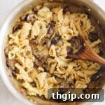 A large pan filled with the finished vegan mushroom stroganoff, mixed with pasta and ready for serving.