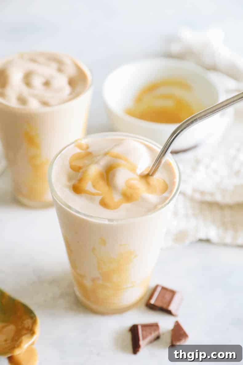 Decadent Healthy Chocolate Peanut Butter Blend 2 A vibrant, healthy chocolate peanut butter smoothie in a clear glass, garnished with a metal straw, invitingly presented for a delicious and nutritious treat.