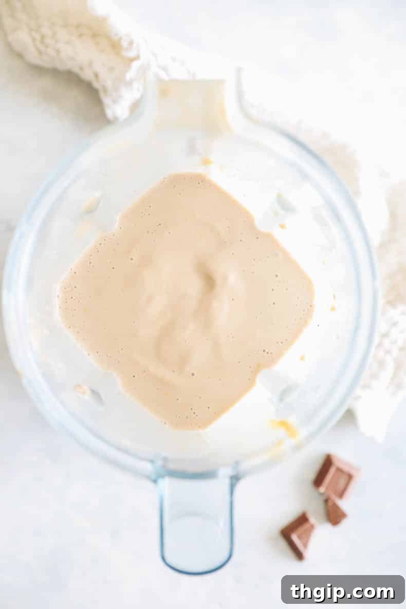 Decadent Healthy Chocolate Peanut Butter Blend 4 A high-speed blender filled with a thick, swirling chocolate peanut butter smoothie, capturing the moment of perfect blending for a creamy texture.