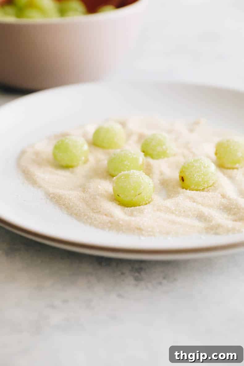 green grapes rolled in sugar on a white plate.