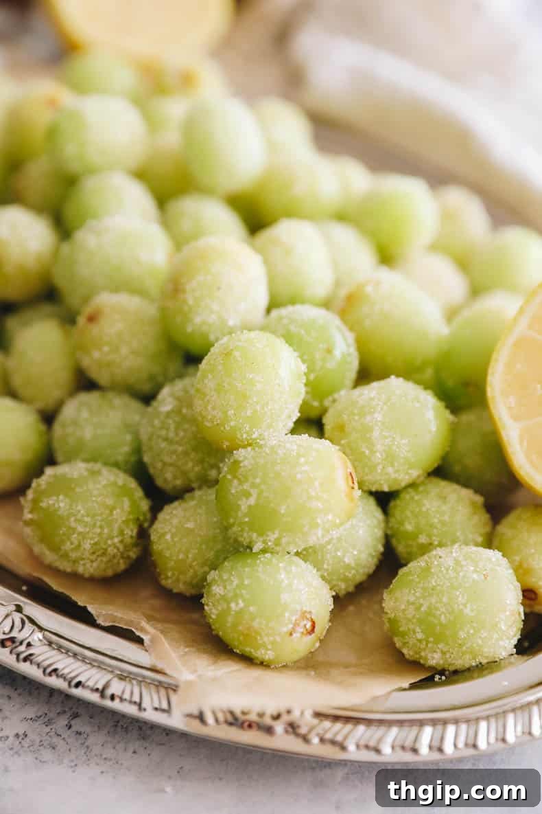 candy grapes coated in sugar on a silver platter.