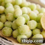 candy grapes with lemon juice and sugar on a parchment lined silver platter.