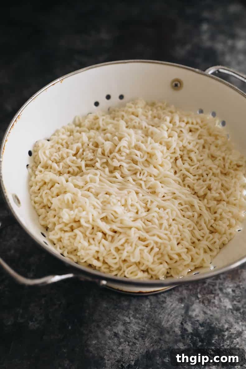 chow mein noodles cooked and drained in a white colander.