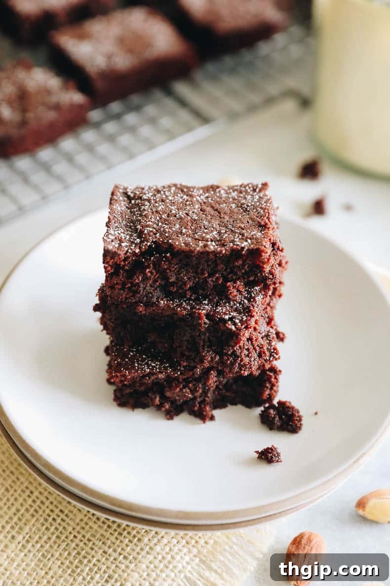 Close-up of a stack of fudgy almond flour brownies, showing the texture.