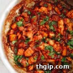 chicken al pastor recipe cooked in a large skillet and topped with cilantro.