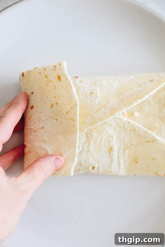 The Perfect Homemade Spinach Feta Breakfast Wrap 7 Folding the wrap neatly to enclose all the ingredients.