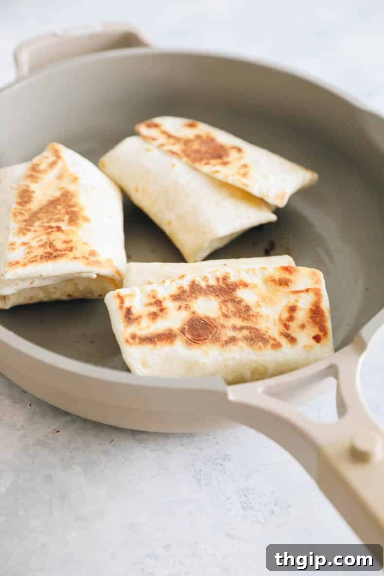 The Perfect Homemade Spinach Feta Breakfast Wrap 8 Cooked Starbucks spinach feta wrap browning in a nonstick skillet.