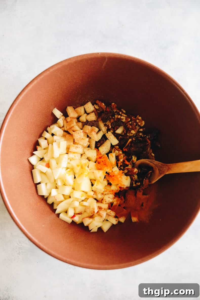 Sweet Charoset for Your Passover Seder 5 Unmixed Charoset ingredients—finely chopped apples, walnuts, dates, and aromatic spices—are artfully displayed in a large brown bowl, poised for combination.