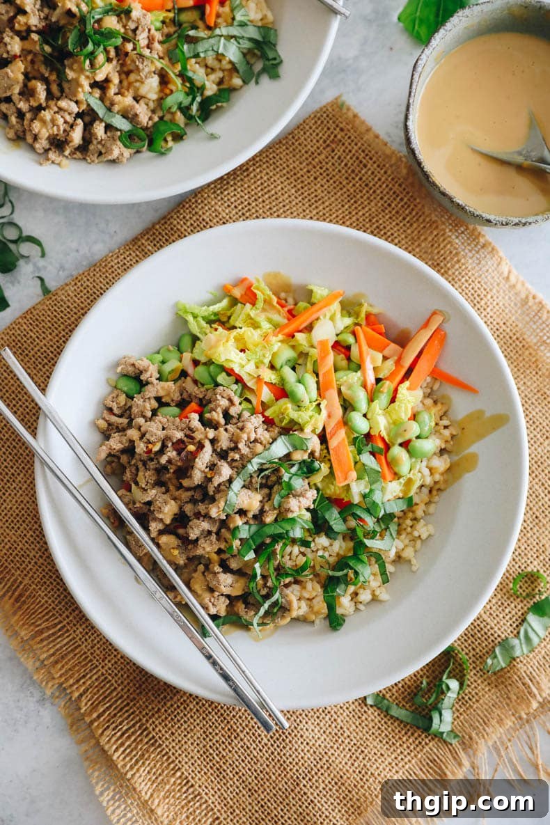 Fragrant Thai Basil Turkey Bowls 8 Thai basil turkey bowls in shallow white bowls with chopsticks and chopped thai basil.
