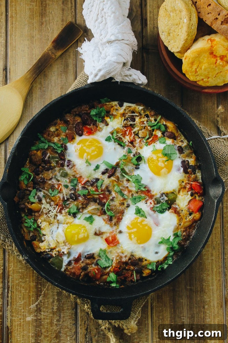 Fiery Baked Shakshuka 2 Warm and hearty Baked Chili Shakshuka in a cast iron skillet, garnished with fresh herbs, ready to be served.