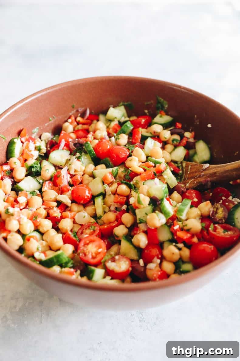 Vibrant Mediterranean Chickpea Medley 4 A large brown bowl filled with Mediterranean chickpea salad, mixed thoroughly and ready to be served.