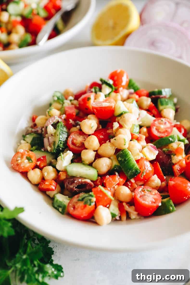 Vibrant Mediterranean Chickpea Medley 5 An up-close detailed image of Mediterranean chickpea salad in a white shallow bowl, highlighting the textures and vibrant colors of the ingredients.