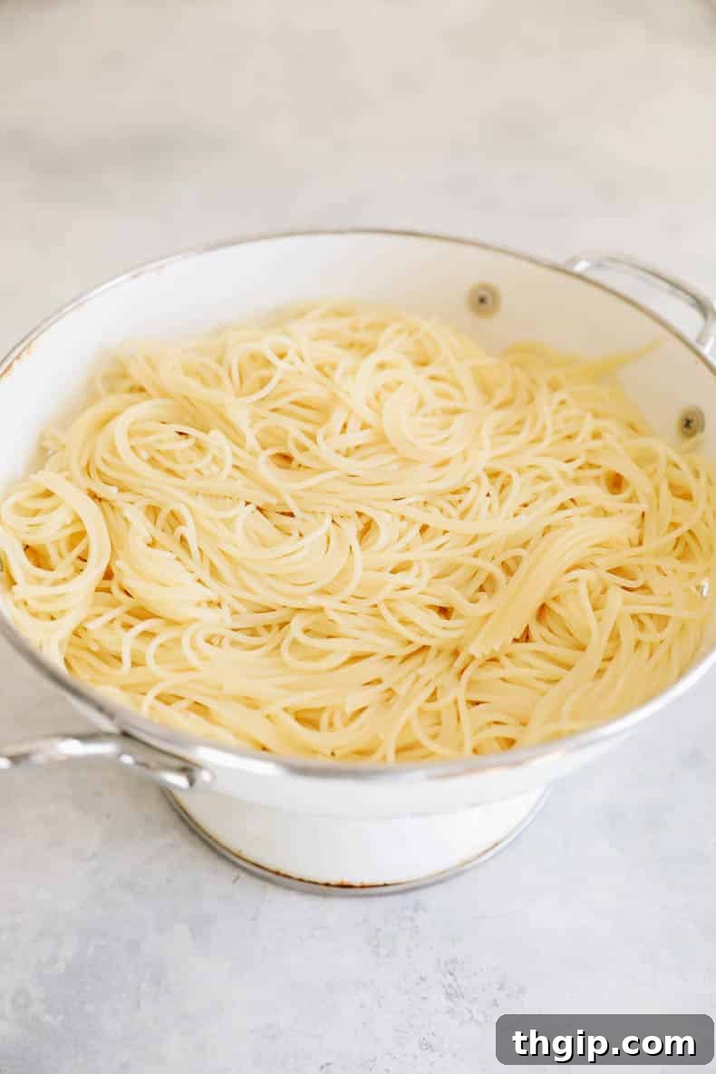 Garlic Butter Lemon Chicken 4 angel hair pasta in a colander.