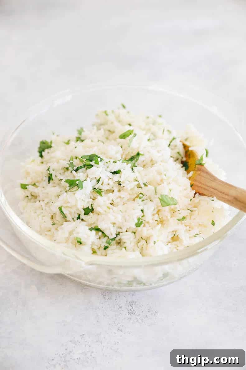 Simple Savory Chicken Burritos 5 Fluffy cilantro lime rice, glistening with fresh lime zest and vibrant green cilantro, in a clear serving bowl.