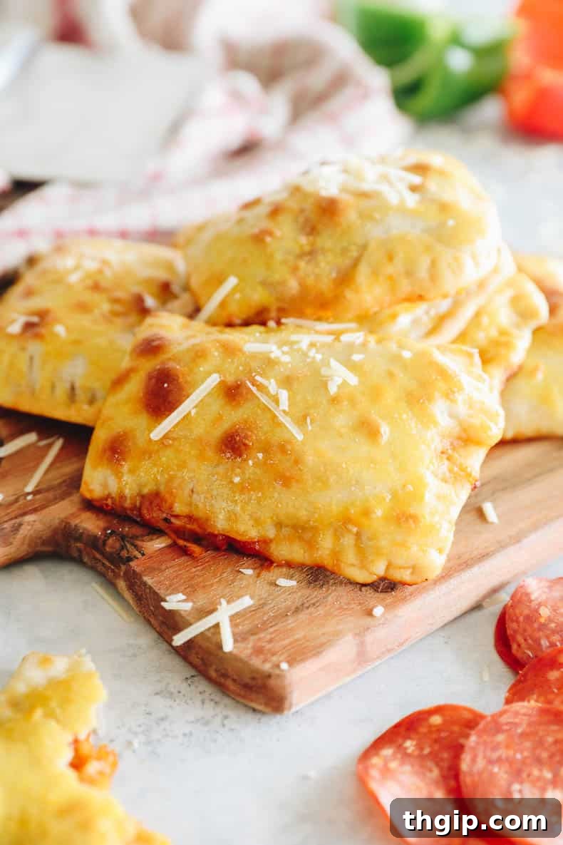 homemade pizza pockets on a wood board, garnished with fresh herbs.