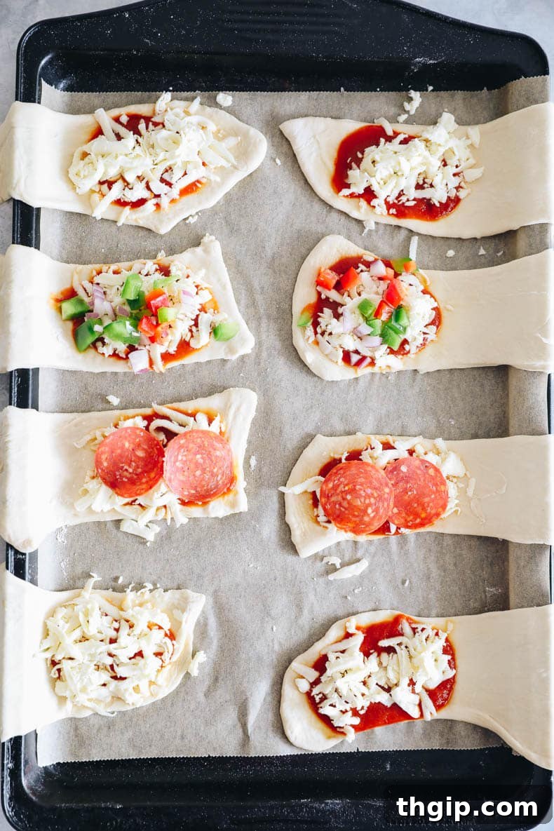 applying pizza sauce to half of a dough rectangle