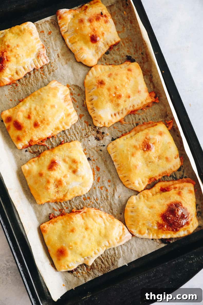 pizza pockets on a baking sheet right out of the oven, golden brown.