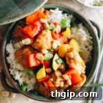 kung pao chicken recipe over rice in a green bowl.