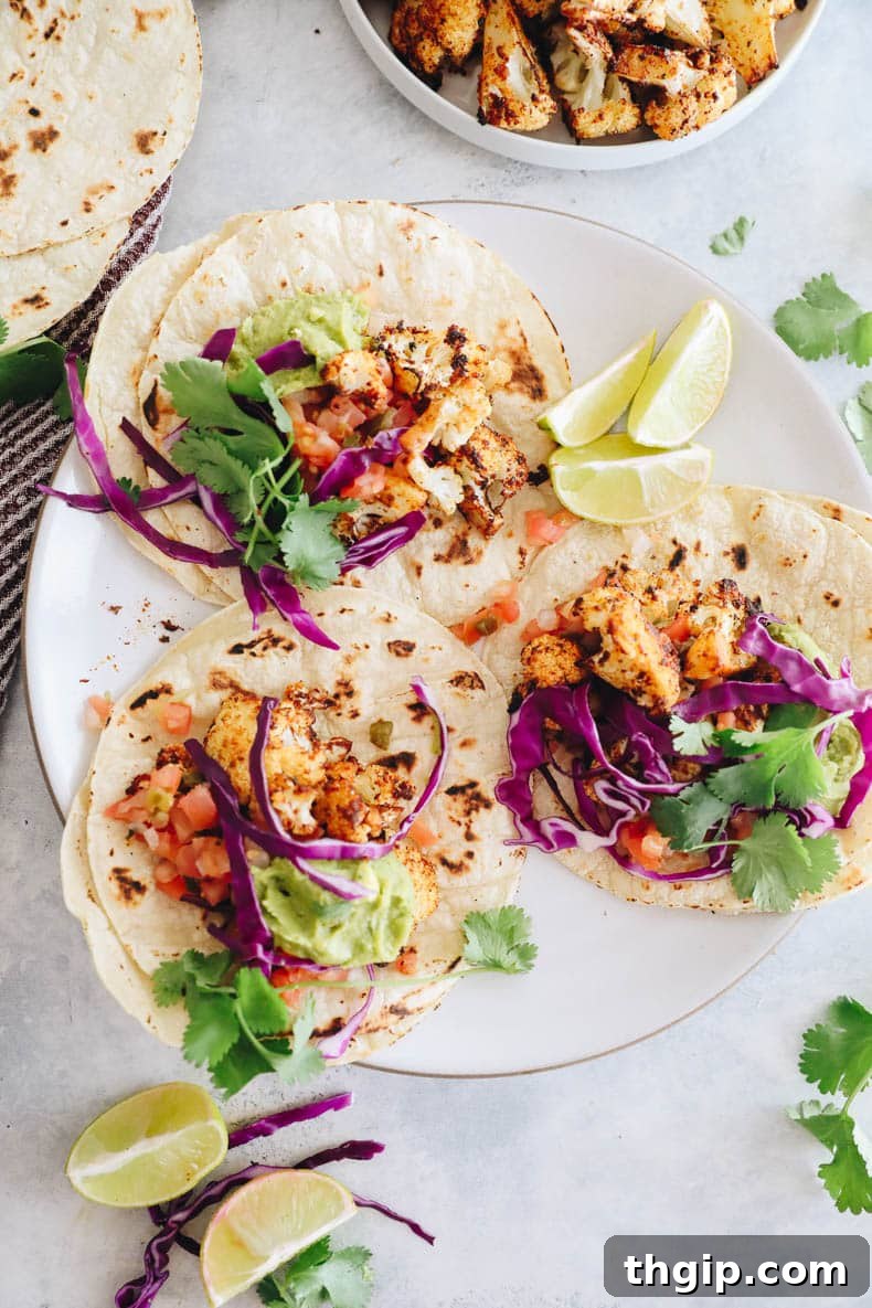 Loaded Crispy Cauliflower Tacos 2 overhead image of cauliflower tacos with guac, pico de gallo, cilantro and purple cabbage.