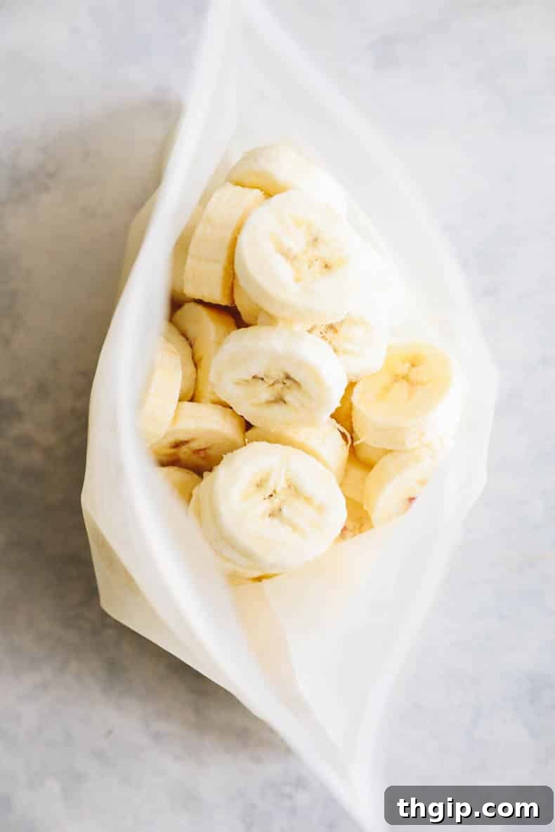 A clear, reusable silicone Stasher bag filled with frozen banana slices, showing an efficient and organized storage method.