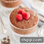 Creamy chocolate chia pudding in a glass cup with fresh raspberries on top, a perfect healthy breakfast or dessert.