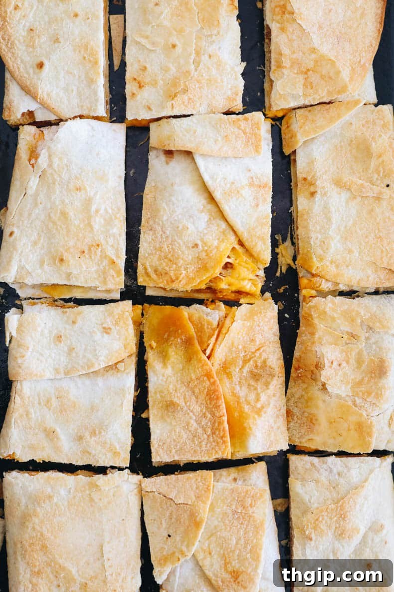 Ultimate Sheet Pan Quesadilla 6 Freshly baked sheet pan quesadillas, golden brown and cut into twelve perfect squares, ready for serving.