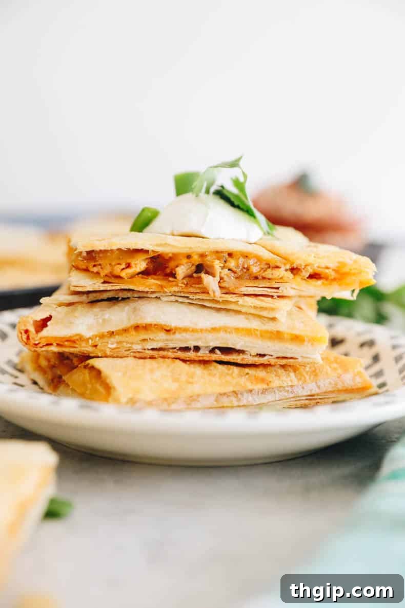Ultimate Sheet Pan Quesadilla 8 A close-up view of a baked sheet pan quesadilla, showing the golden-brown crispy tortilla and melted cheese peeking through.
