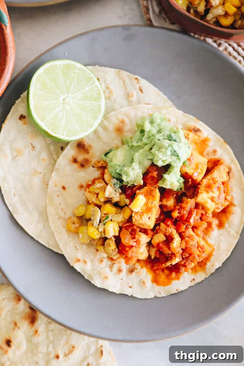 Delicious chipotle sofritas on corn tortillas with fresh guacamole, lime wedges, and corn salsa.