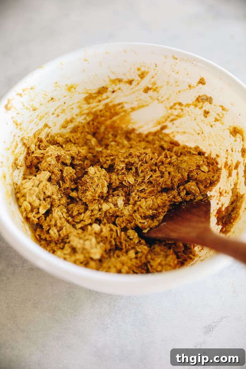 White mixing bowl with pumpkin breakfast cookie dough inside.