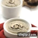 A vibrant, delicious bowl of homemade dairy-free cream of mushroom soup, garnished with fresh herbs and ready to be enjoyed as a healthy comfort meal.